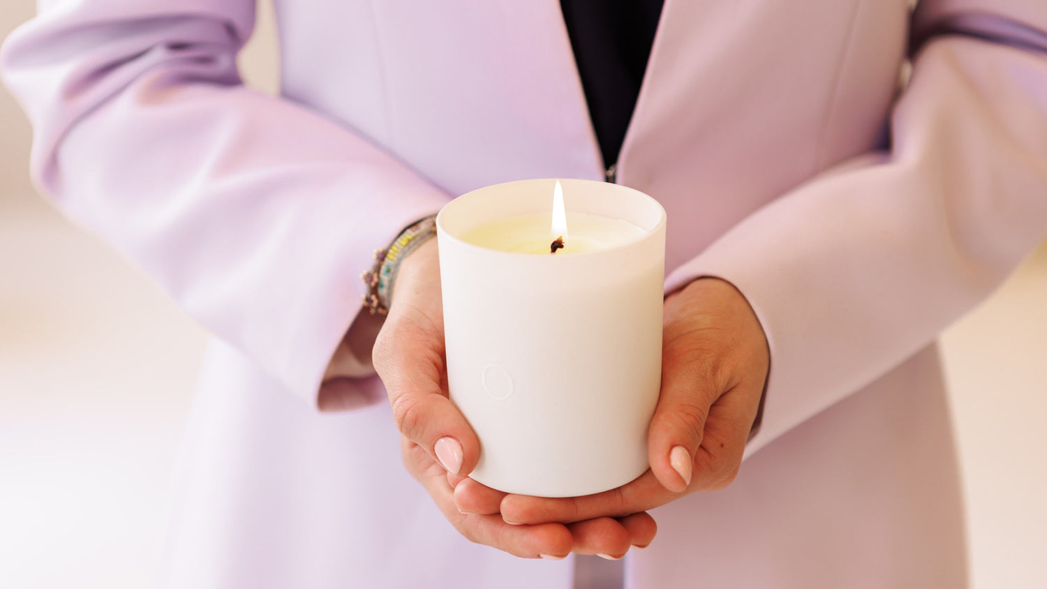 Hands holding a shō-moon meditation candle natural candle