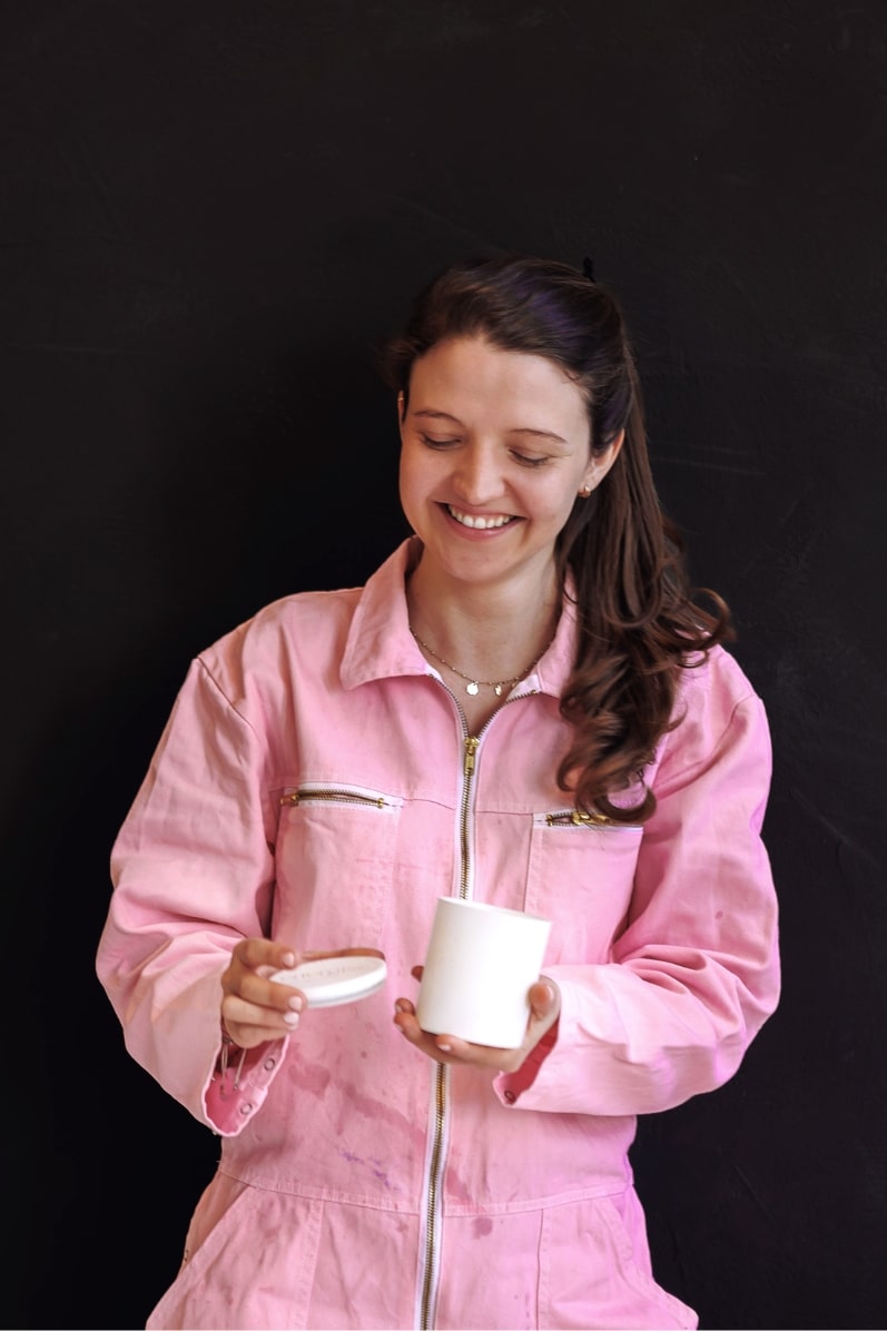 Woman in pink jumpsuit holding shō-moon meditation candle